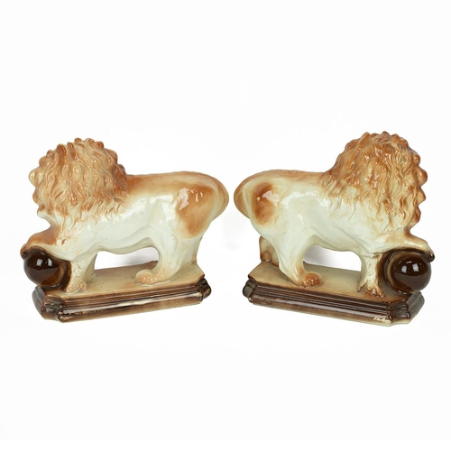 94 - Pair of Staffordshire Lions with paws raised on globes. Height 18cm, Width 33cm. (2) (M)