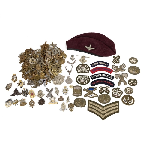 944 - Large group of British Army cap badges, UK and US cloth patches and beret with Parachute Regiment ca... 