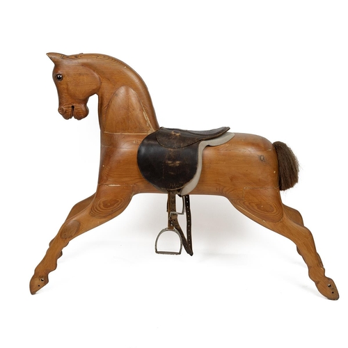 130 - Mid 20th Century carved pine rocking horse, lacking rocking base, with leather saddle and stirrups, ... 