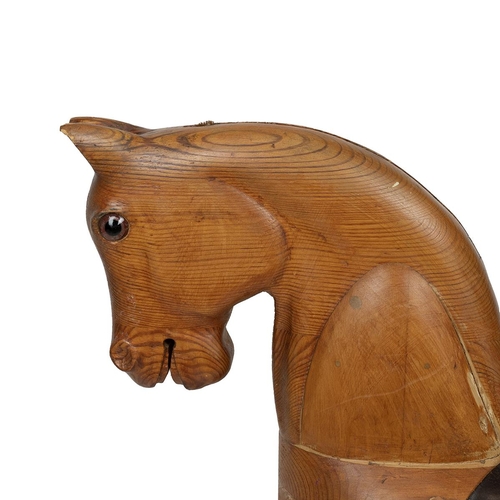 130 - Mid 20th Century carved pine rocking horse, lacking rocking base, with leather saddle and stirrups, ... 