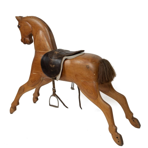 130 - Mid 20th Century carved pine rocking horse, lacking rocking base, with leather saddle and stirrups, ... 