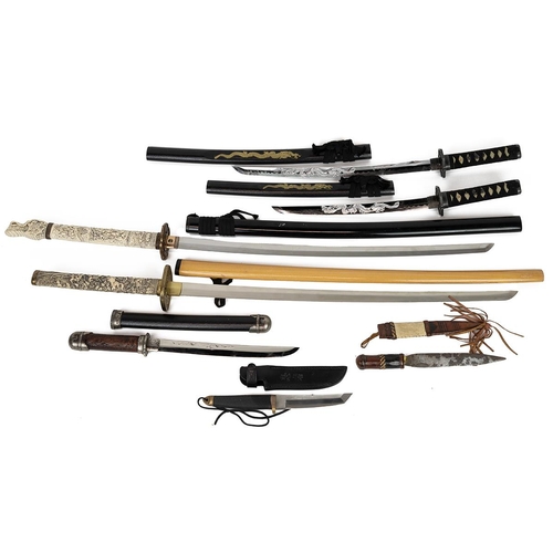 338 - Collection of four reproduction collector samurai swords, the grip decorated with various figures an... 