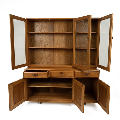 396 - Ercol light elm Windsor design bookcase sideboard. Three glazed doors opening to reveal adjustable s... 