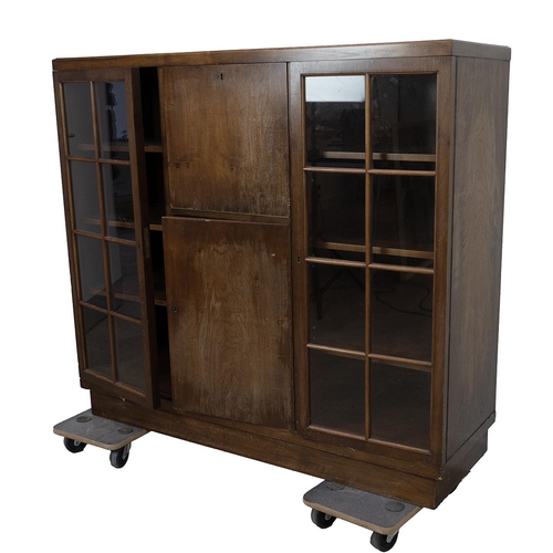 425 - 1930's oak cabinet comprising central drop down door opening to reveal a cocktail cabinet over a cup... 