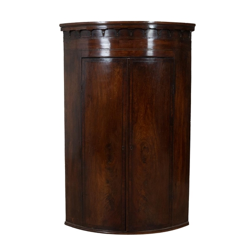 426 - Georgian mahogany bow fronted corner cupboard with ebony and boxwood stringing, castellated pediment... 