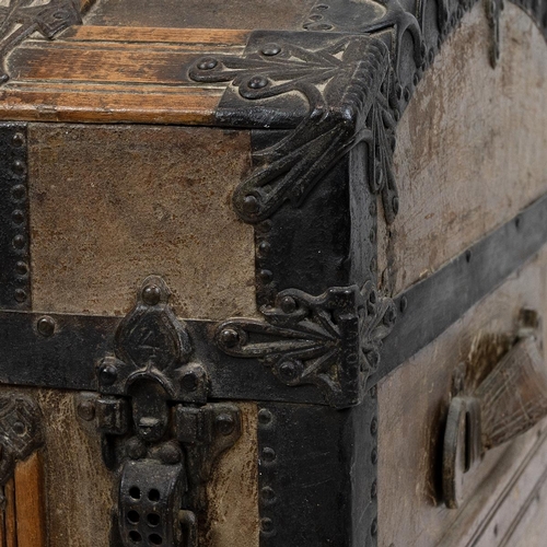 428 - 19th Century iron bound oak domed top trunk the leathered panelled lid opening to reveal a paper lin... 