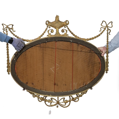 444 - Regency Adams style oval mirror, with bevelled glass, the gilt wooden frame decorated with gilt bras... 