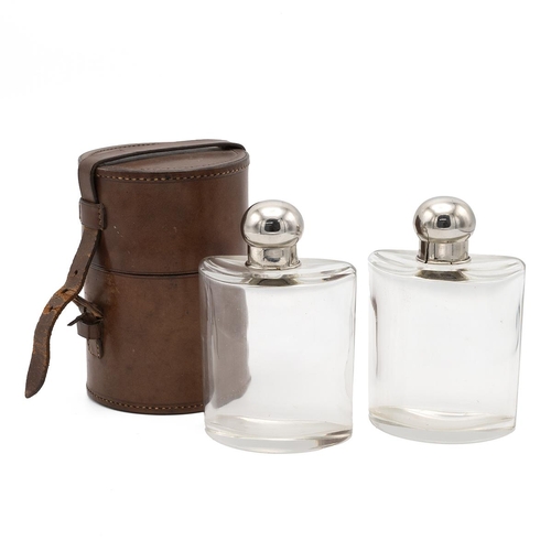 78 - Pair of early 20th century travelling spirit flasks, of semi-circular form with chromed tops, contai... 