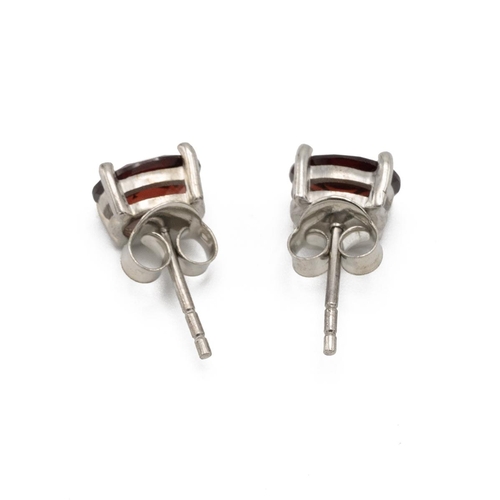 142 - Pair of silver backed garnet ear studs. 