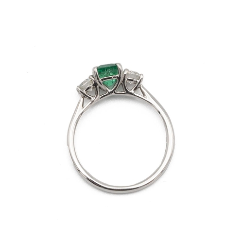 16 - Emerald and diamond three stone ring, the square cut stone flanked either side by a brilliant cut, t... 