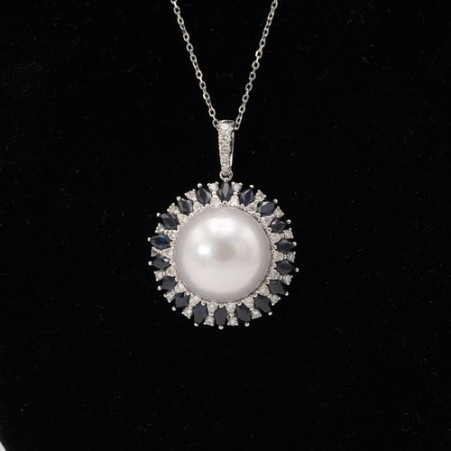 195 - South Sea cultured pearl, diamond and sapphire cluster pendant on a chain, the 14 mm diameter pearl ... 