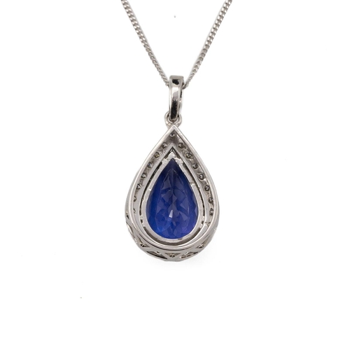 197 - A tanzanite and diamond pendant on a chain, the pendeloque cut stone measuring approximately 15.5 mm... 