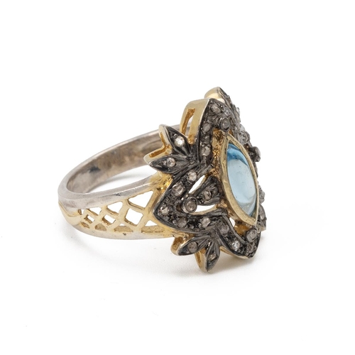 20 - Cluster ring set with diamonds around a central blue topaz cabochon, finger size N.