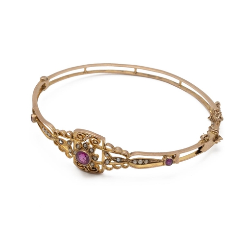 202 - An early 20th-century synthetic ruby and seed pearl hinged bangle, stamped ‘9ct’ to the catch, inner... 