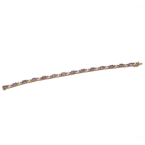 215 - A diamond and amethyst 9ct gold bracelet, the fourteen oval cuts with pairs of small single cuts bet... 