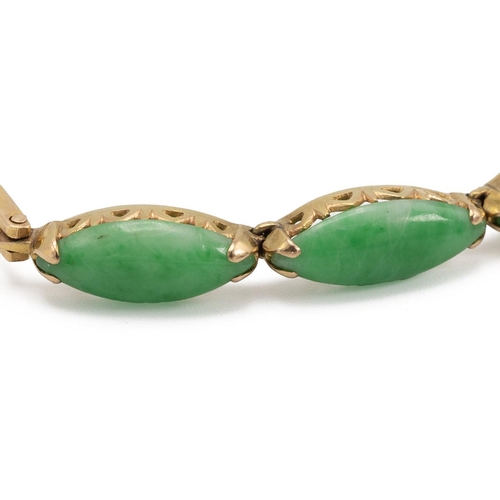 217 - A four-stone jade bracelet, the marquise-shaped cabochons to a yellow metal bracelet with indistinct... 