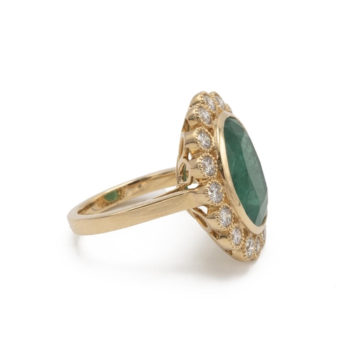 29 - An emerald and diamond cluster ring, the large oval cut measuring approximately 15 by 12 by 6.6mm de... 