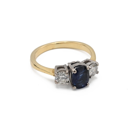 3 - An 18ct yellow gold sapphire and diamond three stone ring, the oval cut sapphire flanked by two roun... 