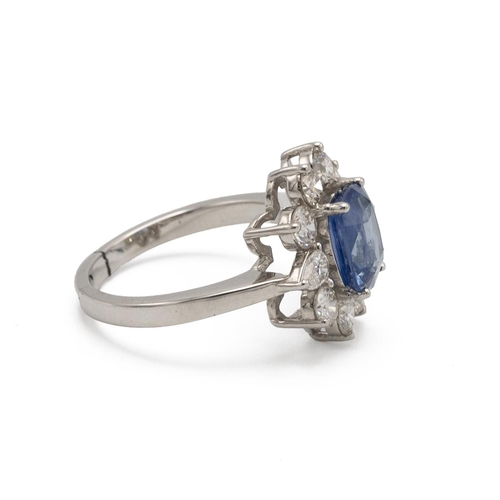 32 - Sapphire and diamond cluster ring, the native cut stone enclosed by eight brilliant cuts and two pen... 