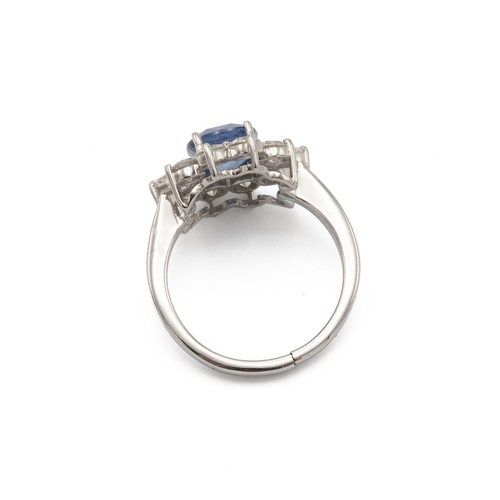 32 - Sapphire and diamond cluster ring, the native cut stone enclosed by eight brilliant cuts and two pen... 