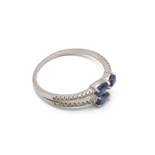 57 - Three stone sapphire and diamond dress ring, the three pendeloque cut stones with lines of small dia... 