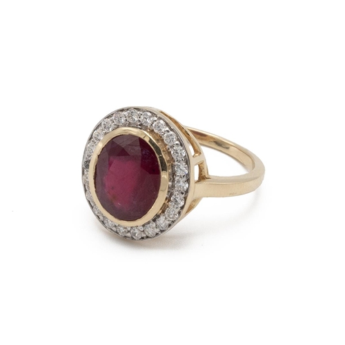 61 - Ruby and diamond cluster ring, the oval cut stone enclosed by twenty-two small brilliant cuts, the y... 