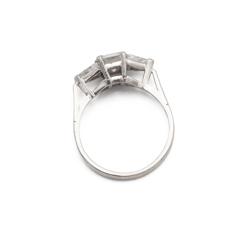 77 - A three stone diamond set platinum ring, the central step cut diamond estimated as weighing approxim... 