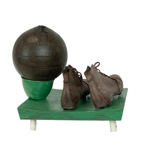 275 - Football/sporting intrest - A vintage pair of leather football boots and leather football, on a wood... 