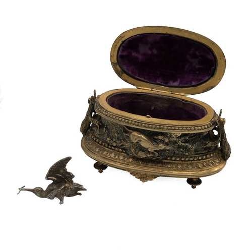 306 - After Jules Moigniez, a gilt brass velvet lined jewellery box, oval form, decorated in relief with a... 