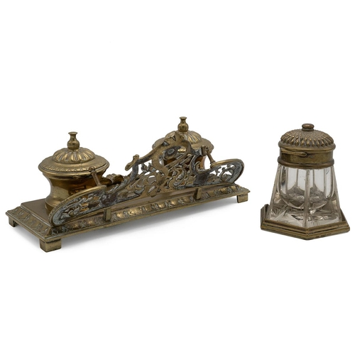 310 - A Rocco style twin brass desk inkwell with pierced gallery rail raised on a stepped base decorated w... 