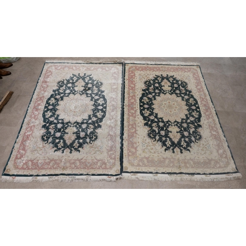 411 - Pair of 20th-century Middle Eastern silk and wool rugs, each decorated with a central medallion on a... 