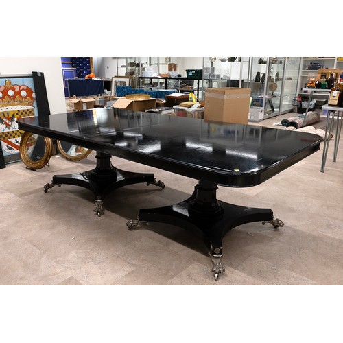 505 - Regency style ebonised pedestal dining table, the top with rounded corners raised on two octagonal s... 