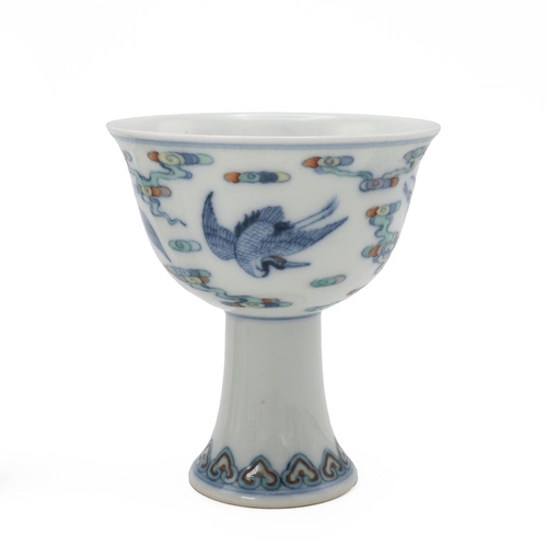 91 - THREE CHINESE PORCELAIN ITEMS, 20TH CENTURYThe Doucai stem wine cup, depicting cranes flying among c... 