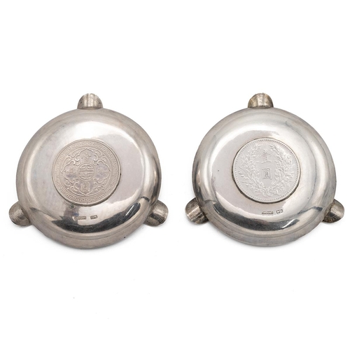 364 - PAIR OF CHINESE SILVER ASHTRAYS WITH COINS TO THE WELL.Both of circular form with dimple effect to t... 