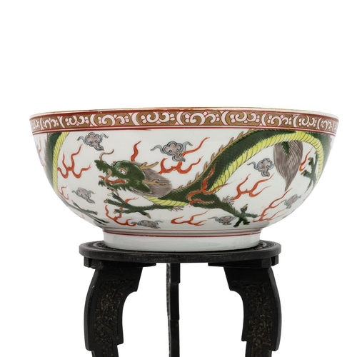 104 - AN ORIENTAL PUNCH BOWL ON WOODEN STAND, EARLY 20TH CENTURYPainted with two flying green dragons amon... 