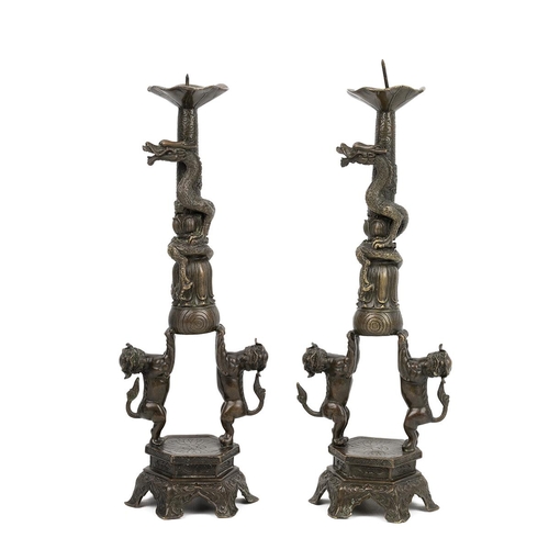 353 - AN IDENTICAL PAIR OF BRONZE CANDLE HOLDERS, QING DYNASTYCrisp detailing, each comprising two Foo dog... 