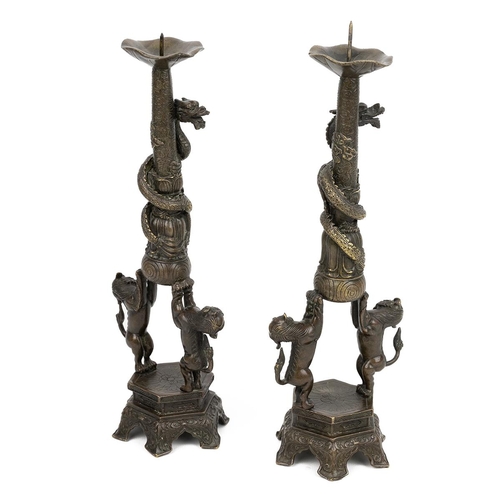 353 - AN IDENTICAL PAIR OF BRONZE CANDLE HOLDERS, QING DYNASTYCrisp detailing, each comprising two Foo dog... 