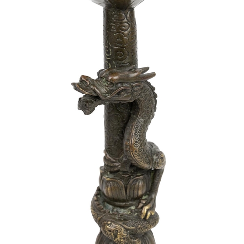 353 - AN IDENTICAL PAIR OF BRONZE CANDLE HOLDERS, QING DYNASTYCrisp detailing, each comprising two Foo dog... 