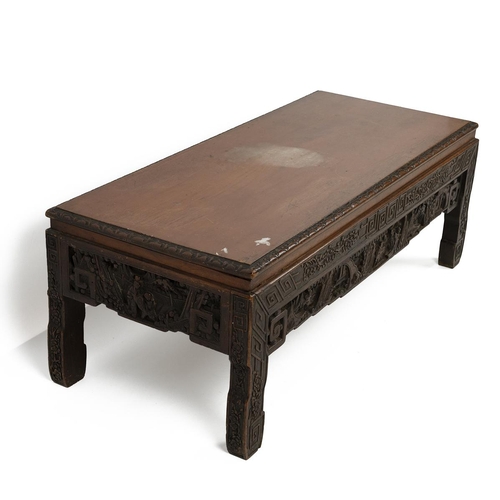 232 - A CHINESE HARDWOOD CARVED KANG TABLE, 19TH CENTURYOf rectangular form with carved floral motifs to t... 