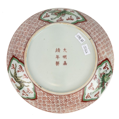 128 - A CHINESE FAMILLE VERTE PLATE, QING PERIODThe outer rim decorated with a brocade of flowers encasing... 