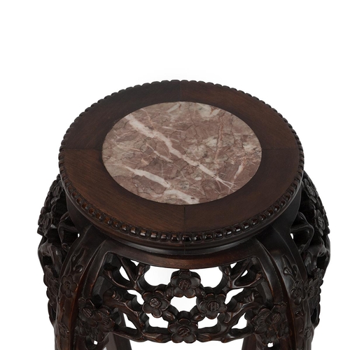 219 - A CHINESE HARD WOOD PLANT STAND.With pink marble inset to the top surrounded by a dragooned frieze a... 