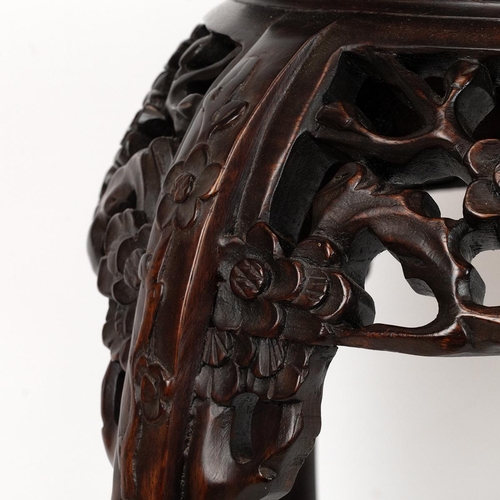 219 - A CHINESE HARD WOOD PLANT STAND.With pink marble inset to the top surrounded by a dragooned frieze a... 