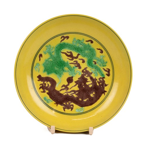 108 - A CHINESE FAMILLE VERTE SAUCER, QING DYNASTYPainted with a green dragon and a brown dragon in the in... 