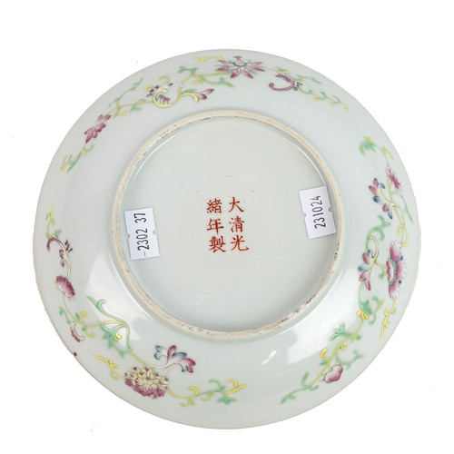 109 - A CHINESE FAMILLE ROSE PLATE, QING DYNASTYA butterfly and a pair of magpies flying among flowers and... 