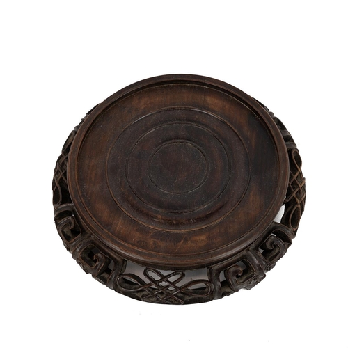 224 - A LARGE CHINESE WOODEN STANDA squat circular stand with pierced outer frieze, raised on four support... 