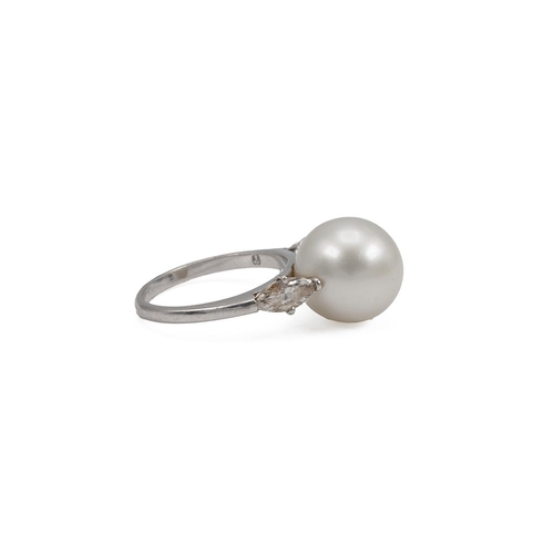 77 - Cultured pearl and diamond ring, centring on a large cultured pearl measuring 13mm, between shoulder... 