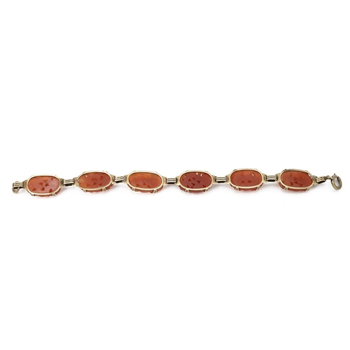 133 - Carnelian bracelet, in unmarked yellow metal, the six oval stones carved with foliage, 19cm long. Te... 