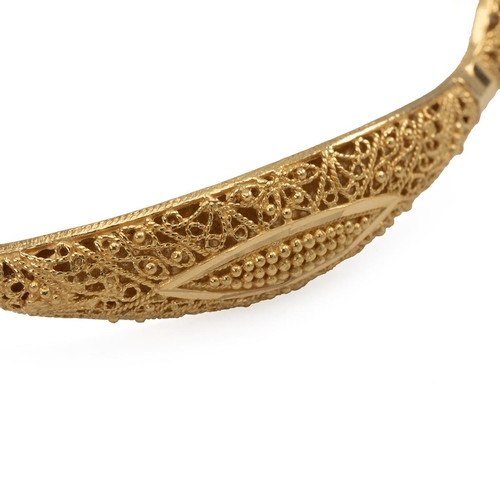 140 - Yellow metal open work pierced bangle of curved outline with repeating lozenge motifs, marked '22ct'... 