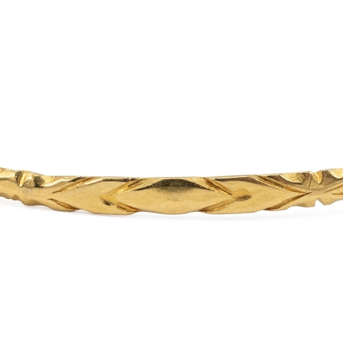 152 - Two yellow metal tested 18ct gold bangles with diamond cut decoration, weight 10 grams.