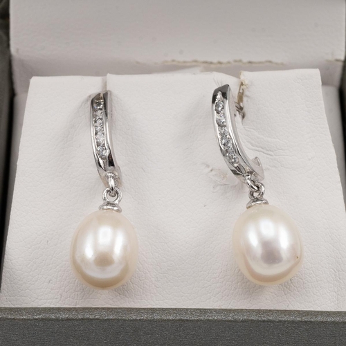 174 - Pair of white metal and cultured pearl earrings, along with another similar pair, both cased.